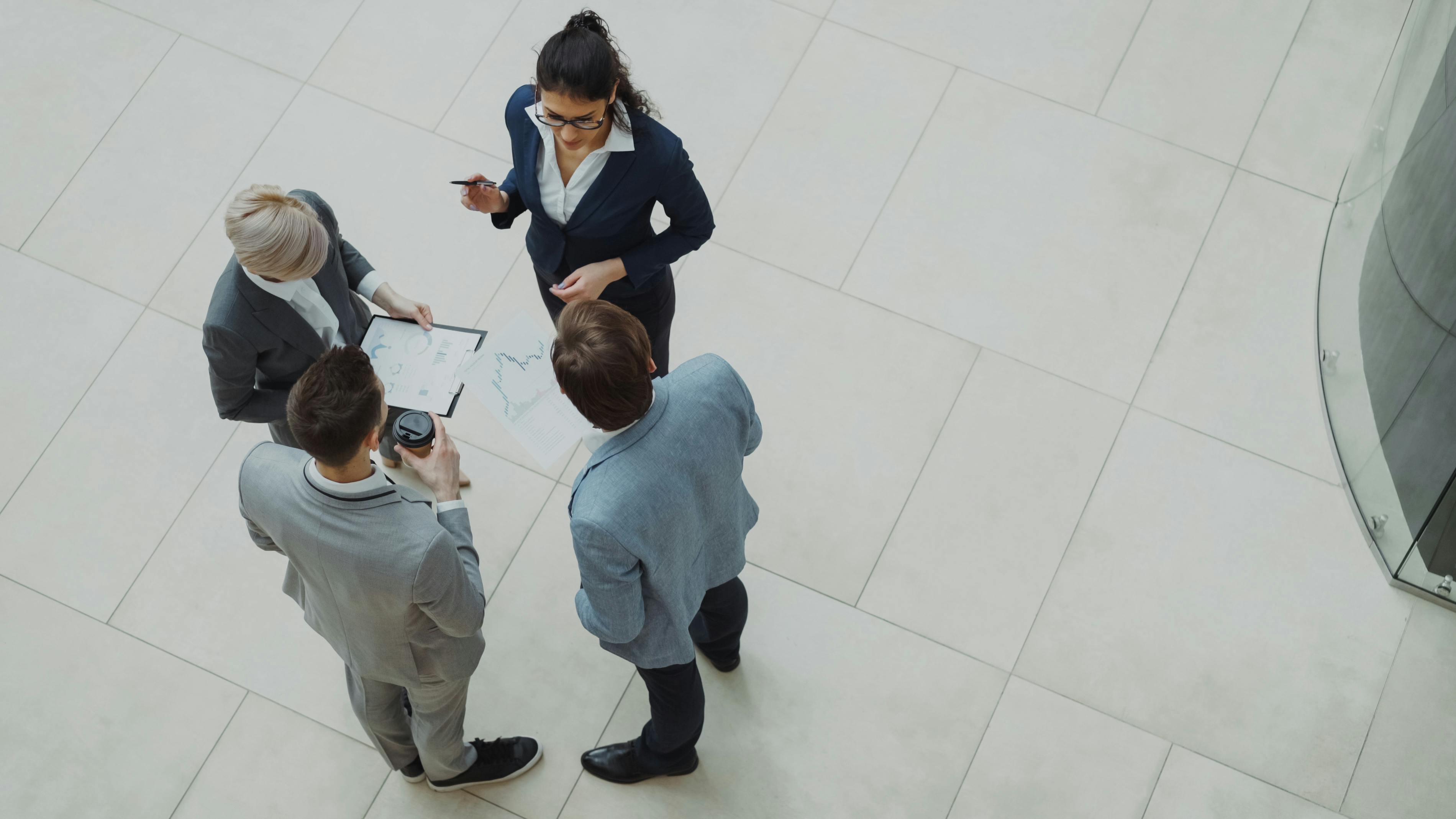 Advisor walking an executive team through a printed diagnostic, viewed from above